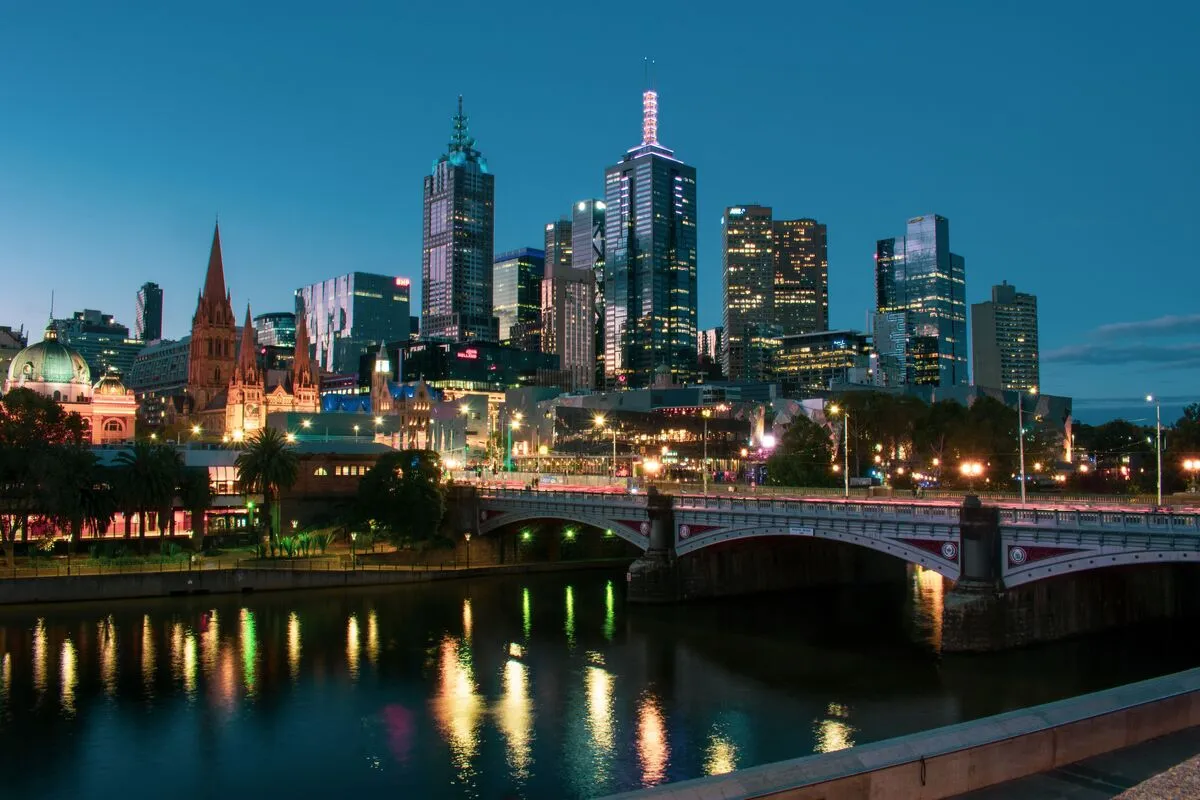 Melbourne CBD skyline at blue hour over the Yarra River, with Princes Bridge lit in the foreground.